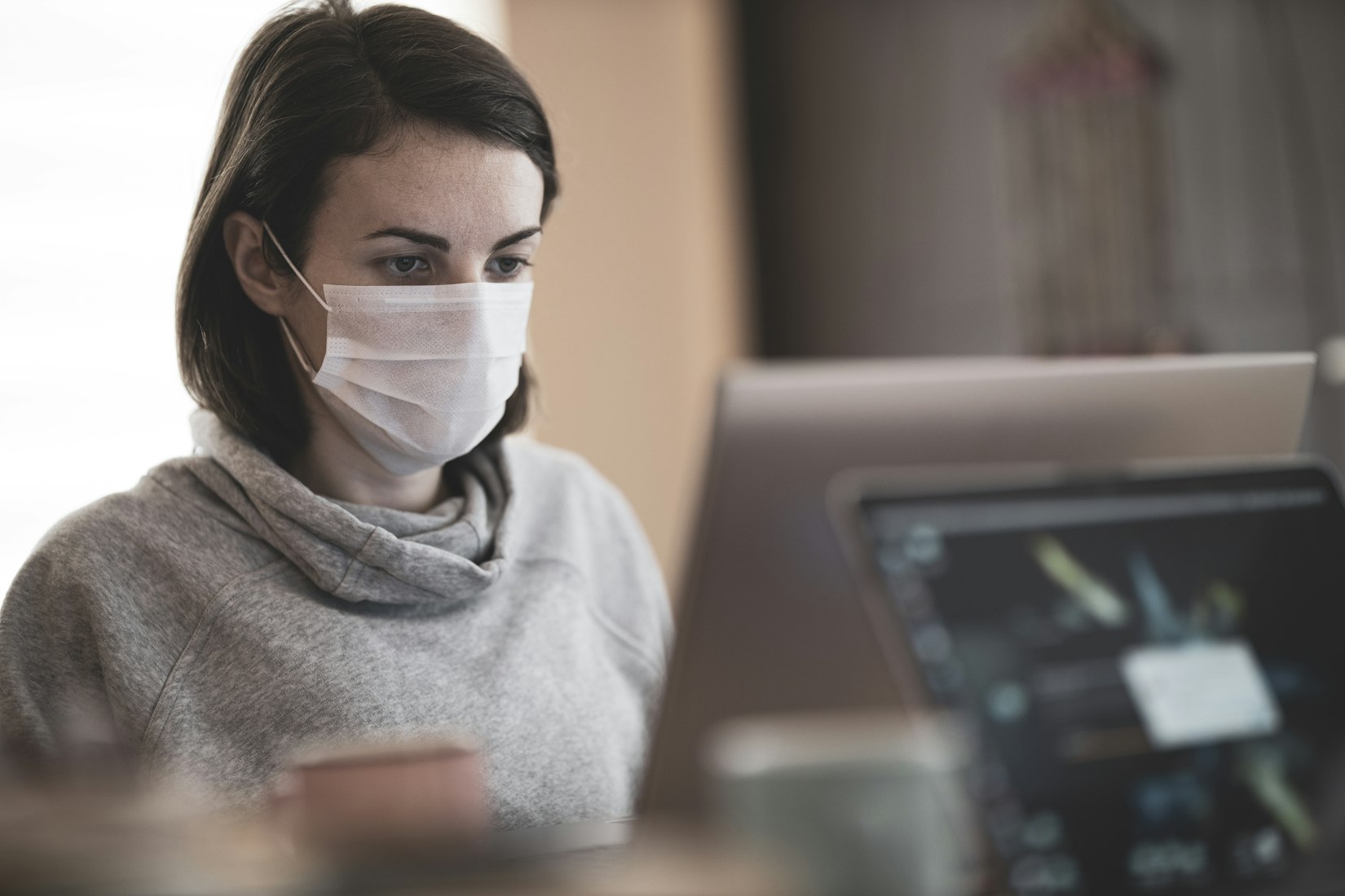 girl with mask on a computer 