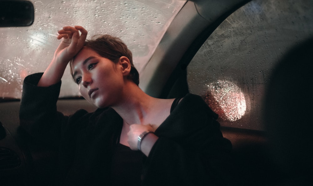 woman in black blazer sitting inside car