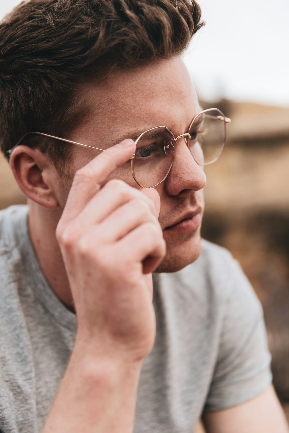 man in gray crew neck shirt wearing silver framed eyeglasses