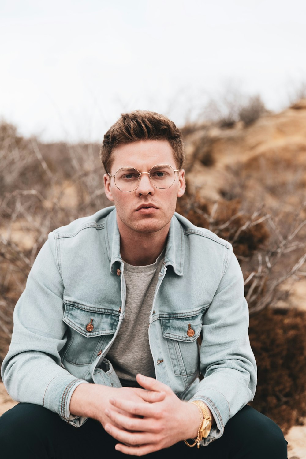 man in gray zip up jacket wearing black framed eyeglasses