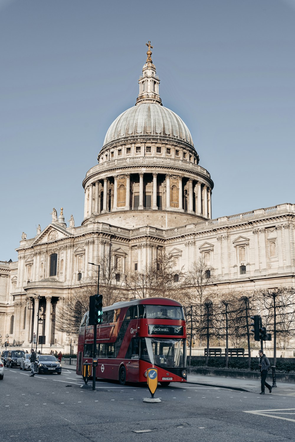 red bus in front of white concrete building during daytime