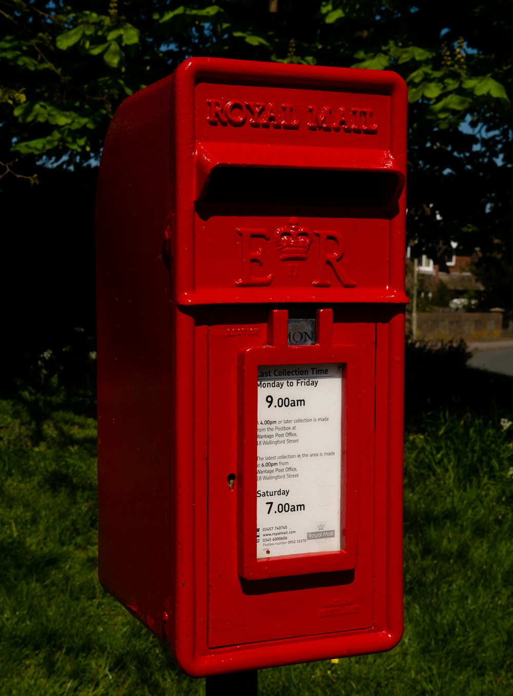 red mail box on green grass field