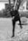 man in black long sleeve shirt and black pants standing on concrete fence