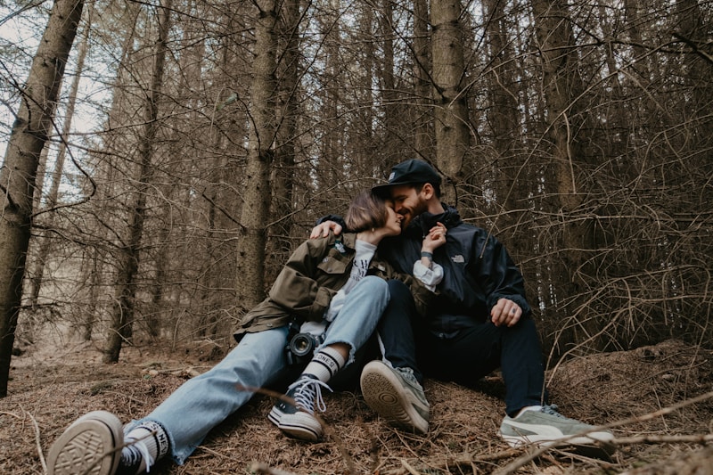 casal sentado em tronco ao ar livre