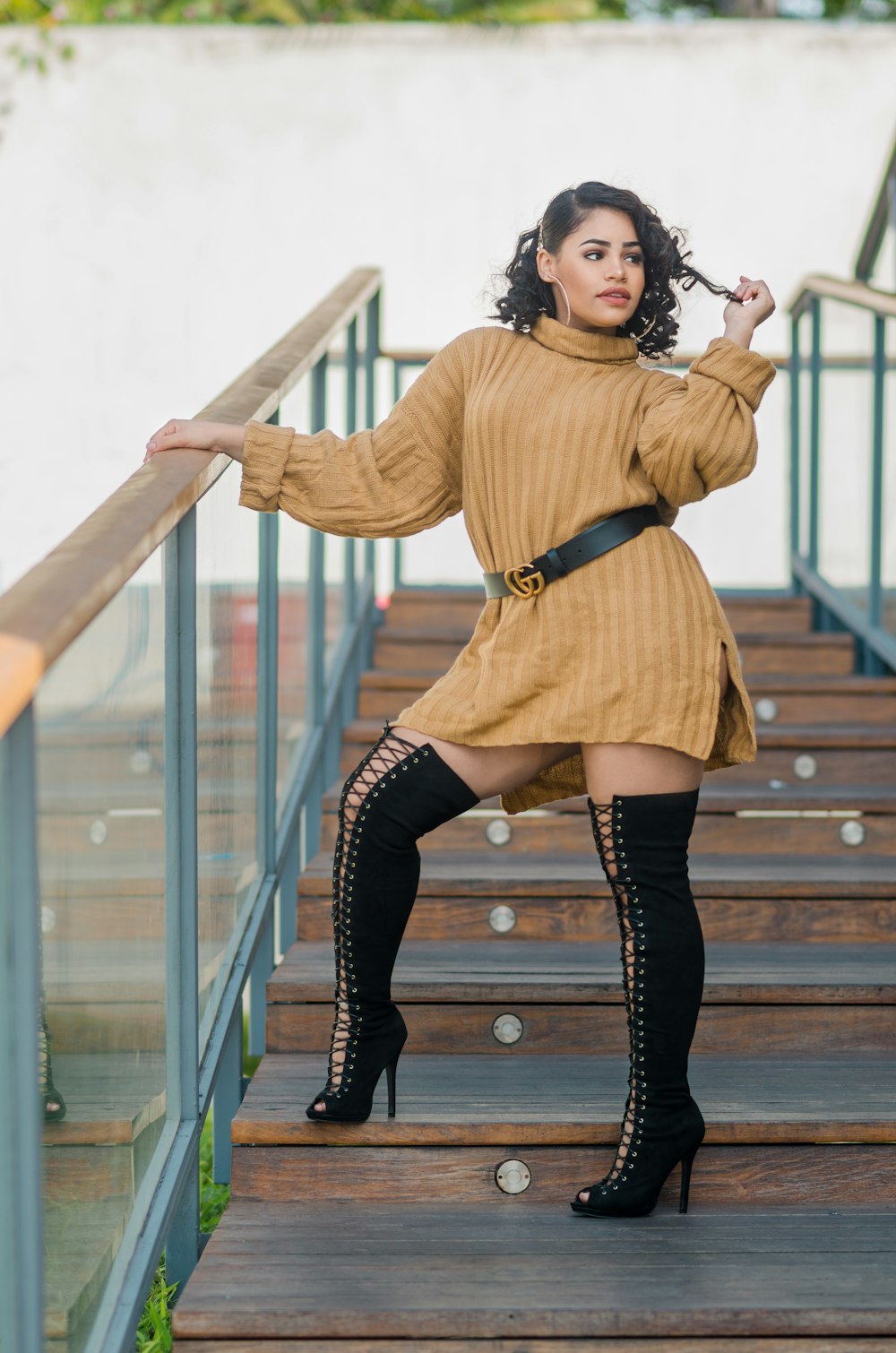 a woman in a brown sweater dress and thigh high boots