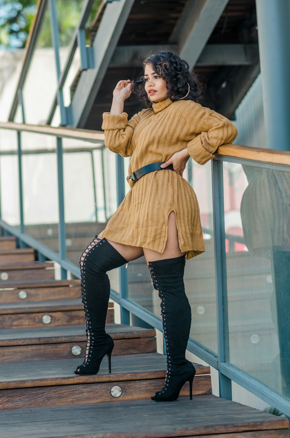 a woman in a brown dress and thigh high boots