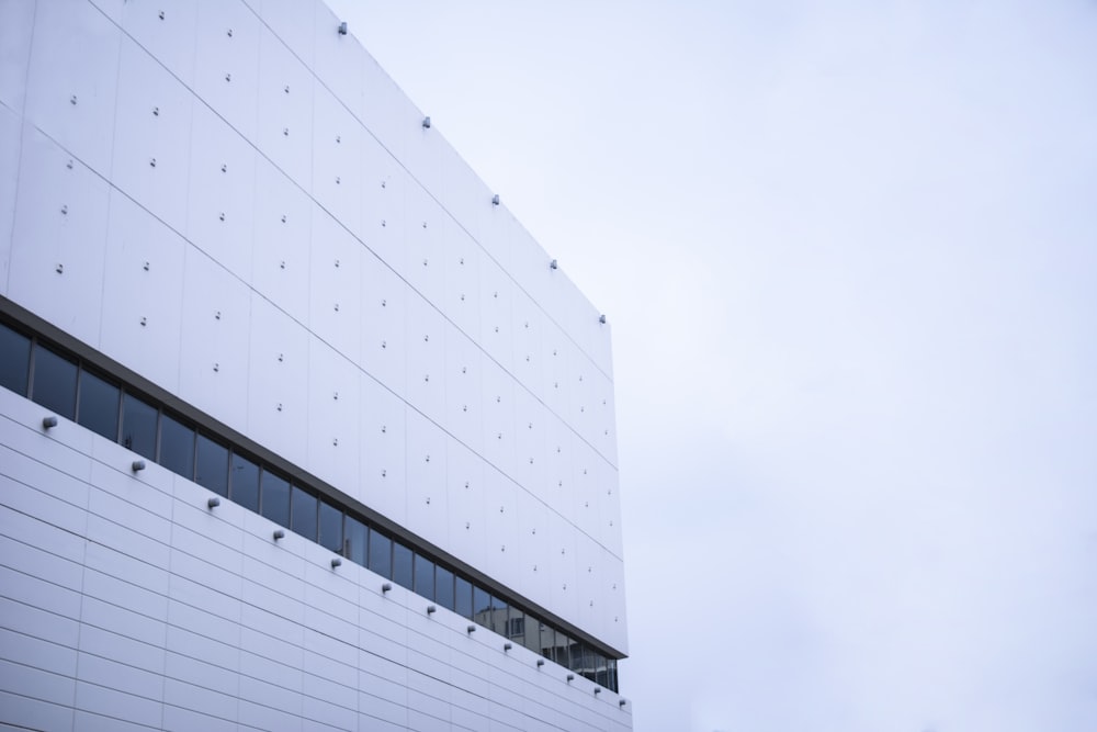 edificio in cemento bianco sotto il cielo bianco durante il giorno