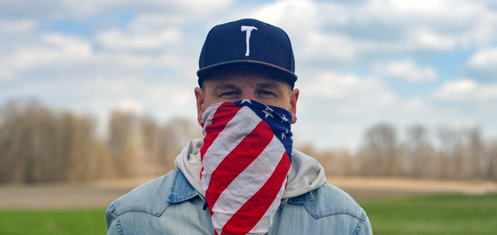 a man wearing a baseball cap and a scarf wrapped around his neck