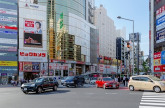 An intersection filled with cars and pedestrians in a bustling city.