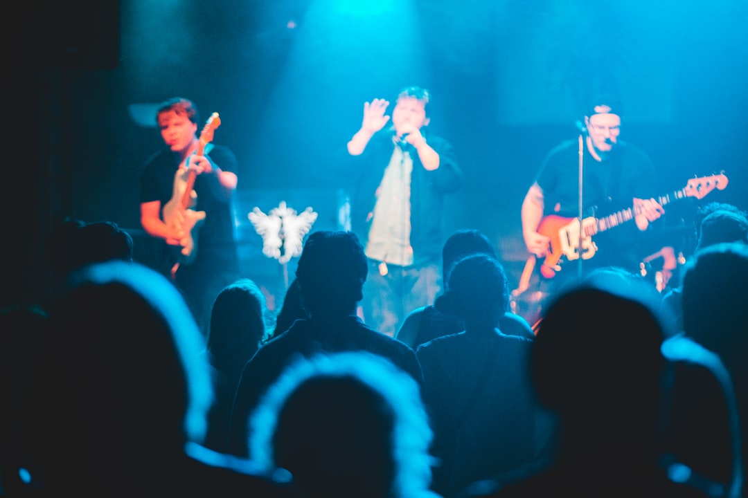 man in white shirt singing on stage