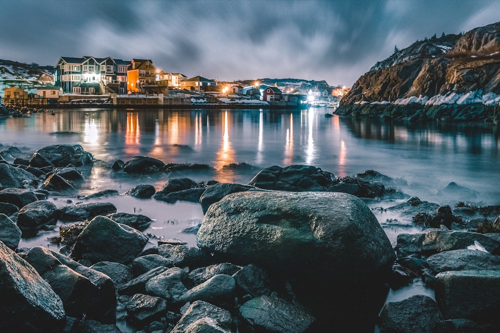 brown and white building near body of water during night time