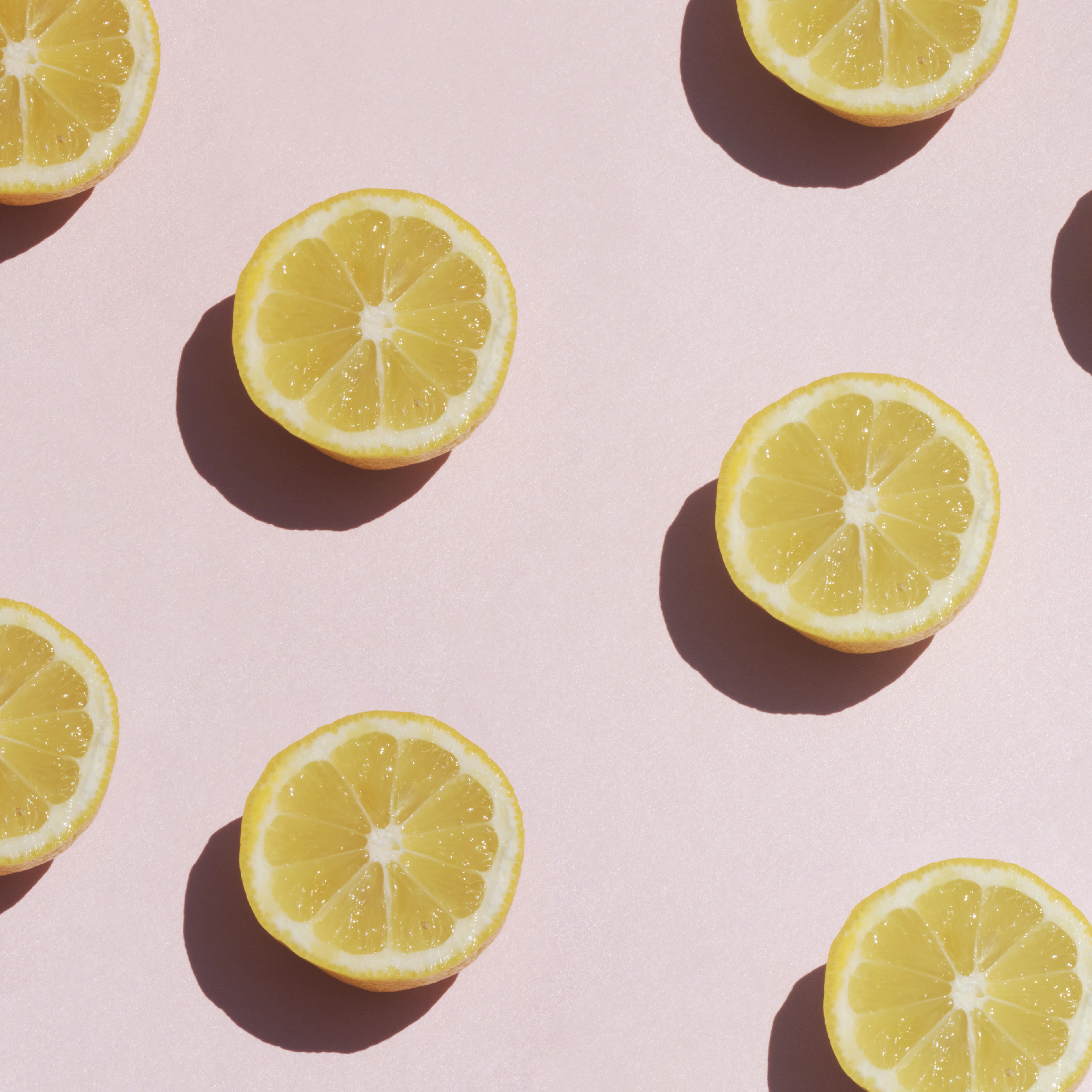 Lemon slices arranged on pastel pink