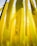 Yellow ribbons with motivational messages hang vertically. One prominent ribbon displays the words 'Be Strong' along with hearts. The background consists of similar yellow ribbons, creating a layered effect.
