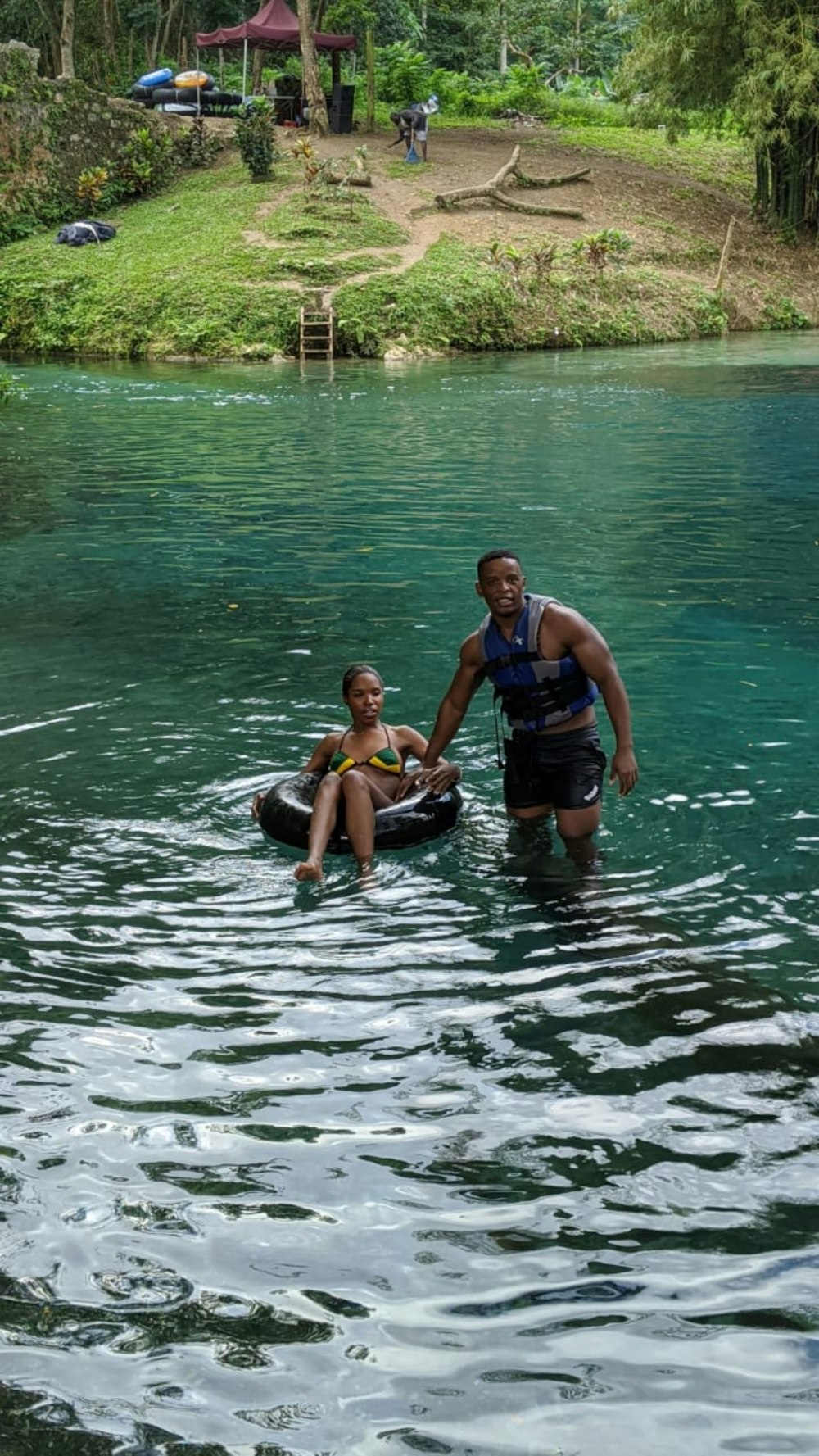 2 women in blue and black swimsuit on water during daytime