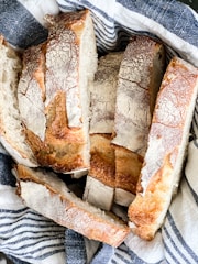 Rows of golden ciabatta loaves lined up on a rustic table.