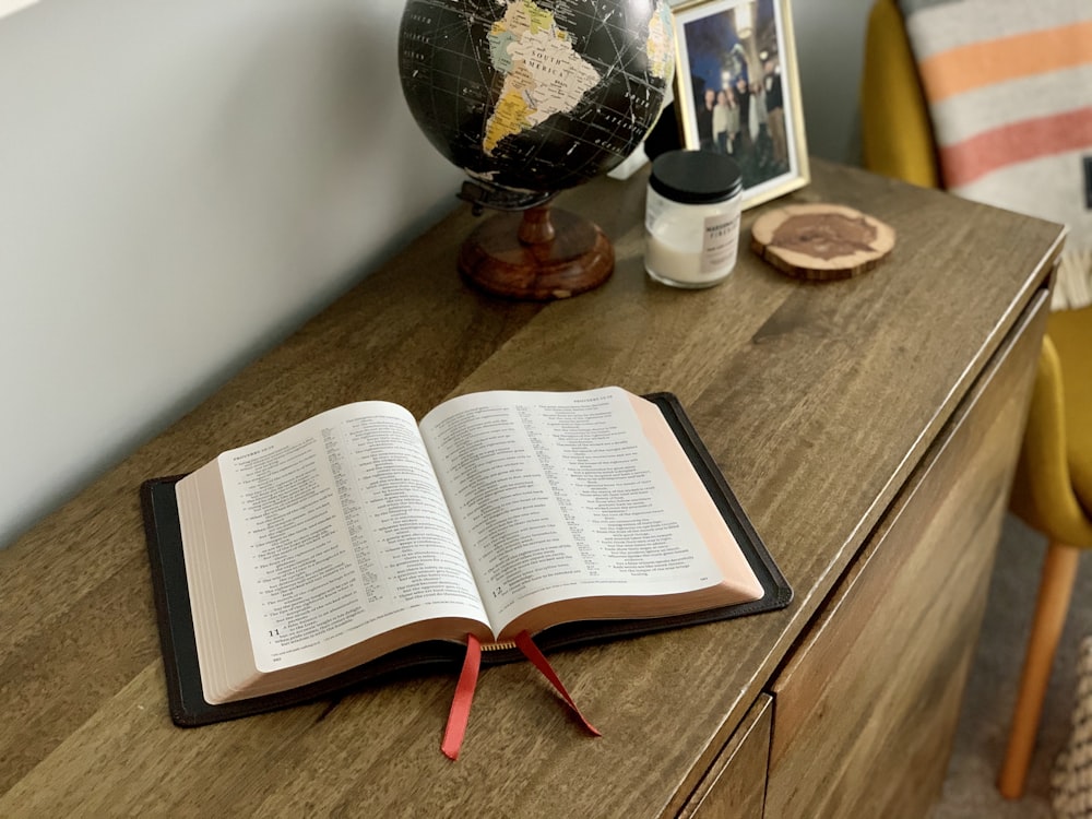 opened book on brown wooden table