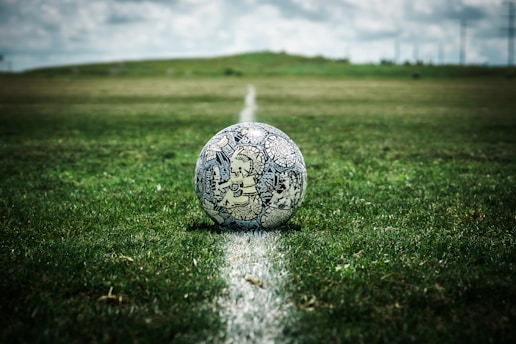white and black soccer ball on green grass field during daytime