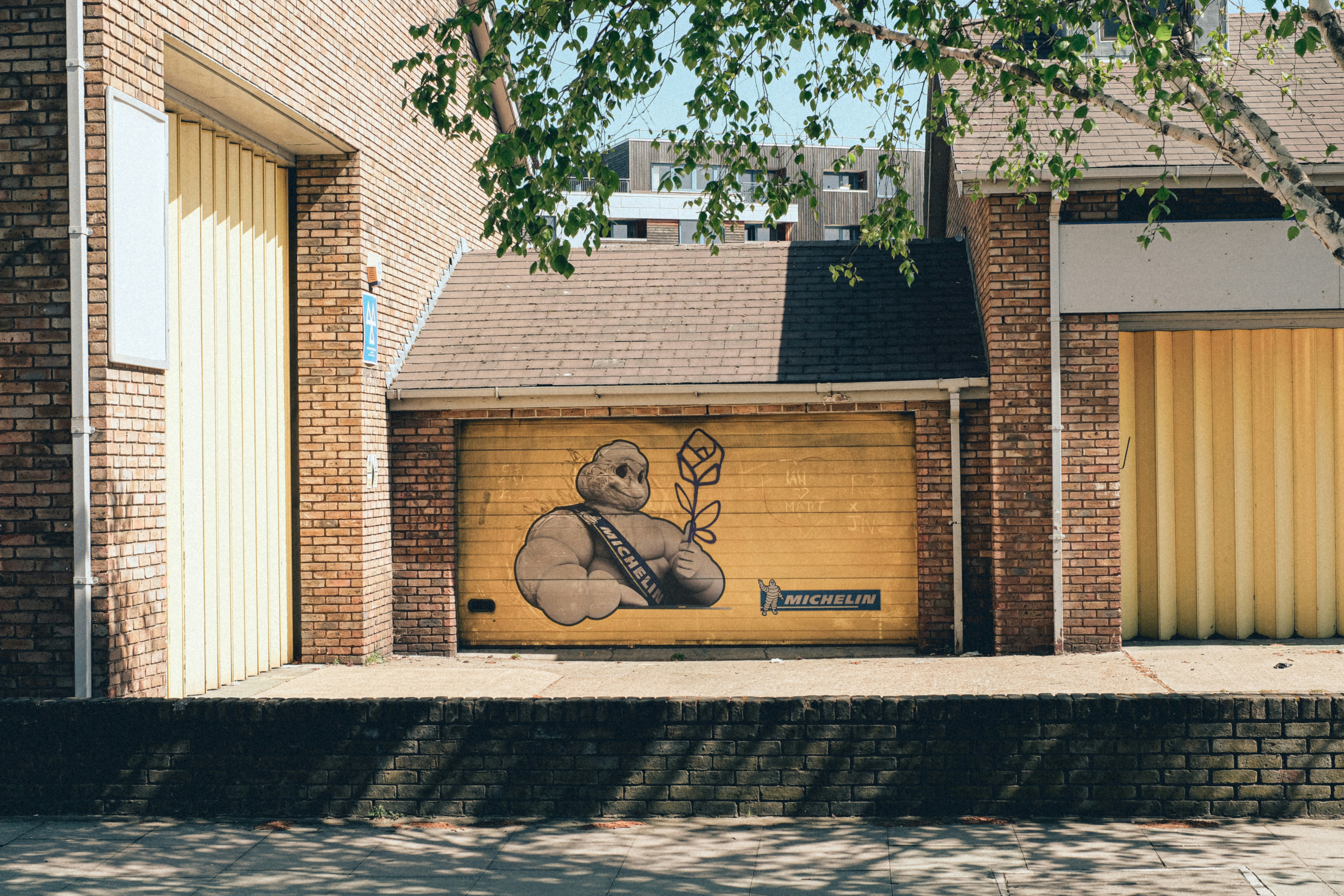 brown brick building with green tree in front