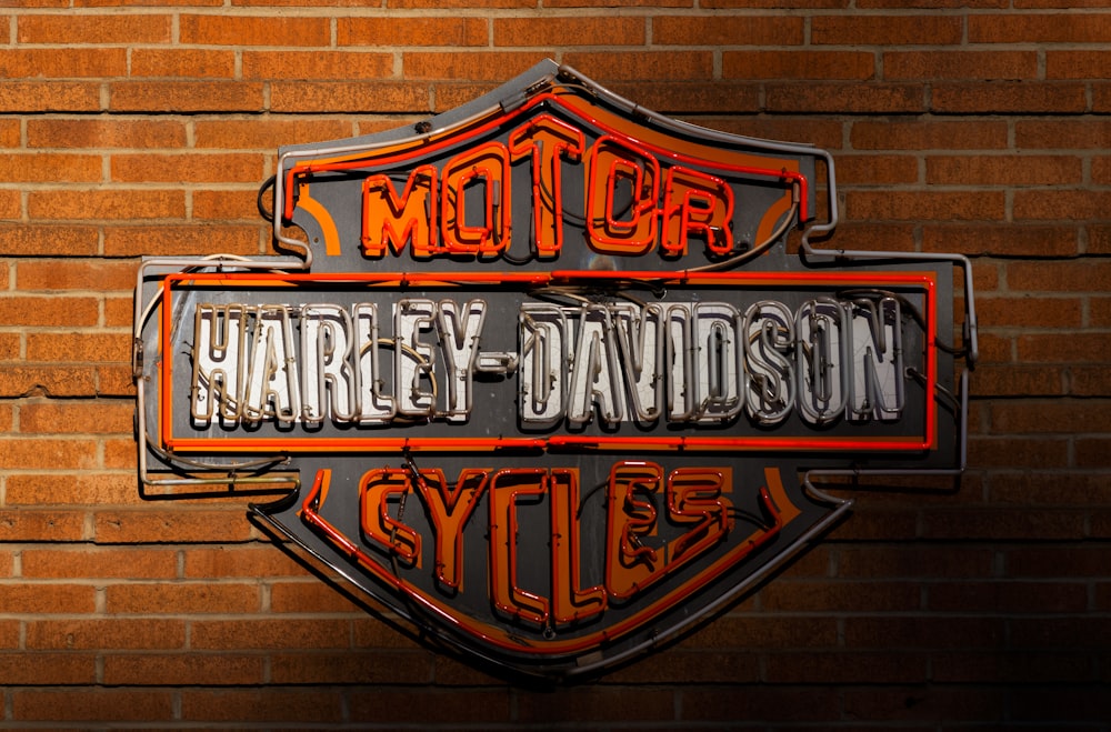 a harley davidson sign on a brick wall