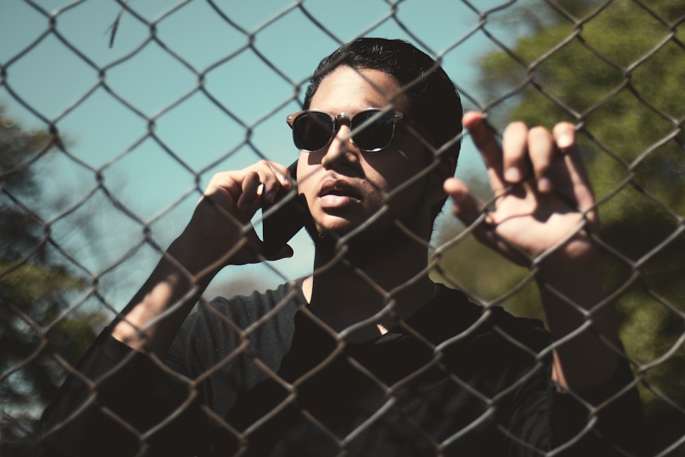 a man wearing sunglasses talking on a cell phone