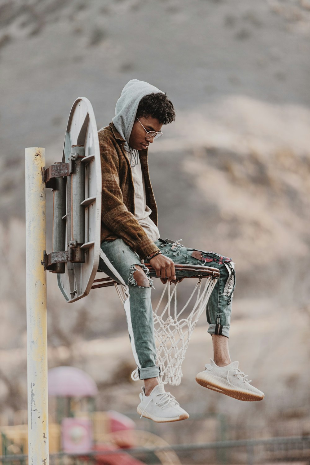 a man sitting on top of a basketball hoop