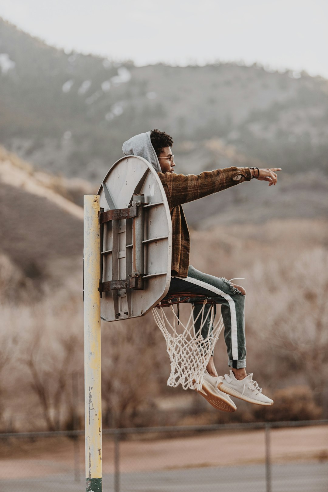 person in brown leather gloves holding basketball hoop