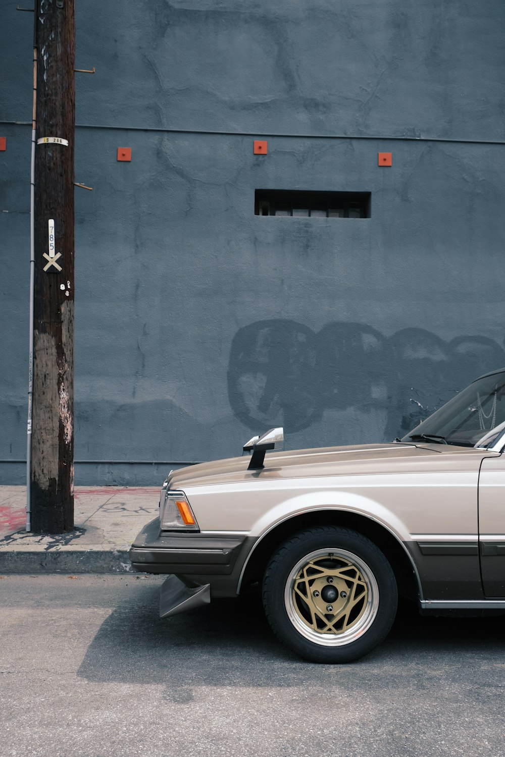 white mercedes benz coupe parked beside gray concrete wall during daytime