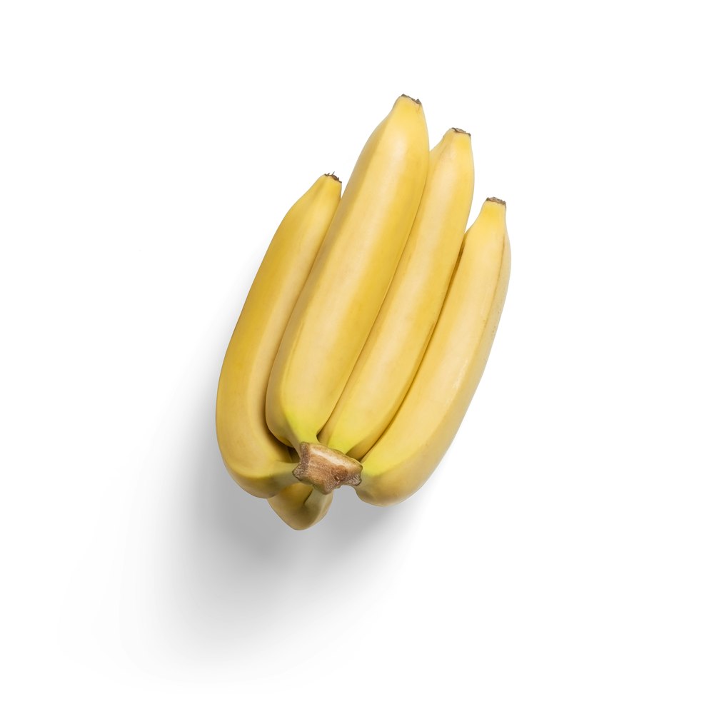 3 frutti di banana gialli su superficie bianca