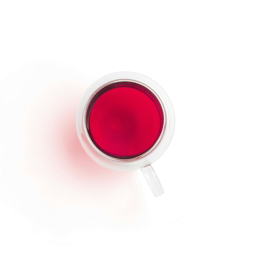 Taza de cerámica roja y blanca con líquido rojo