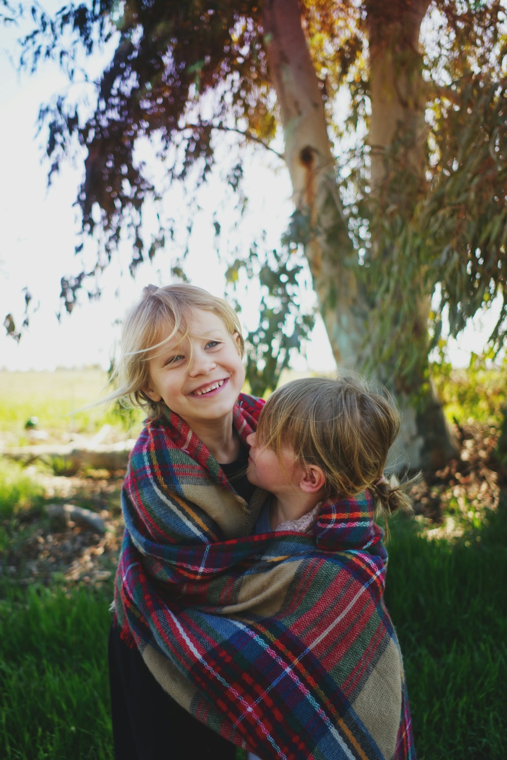 2 girls standing under tree during daytime