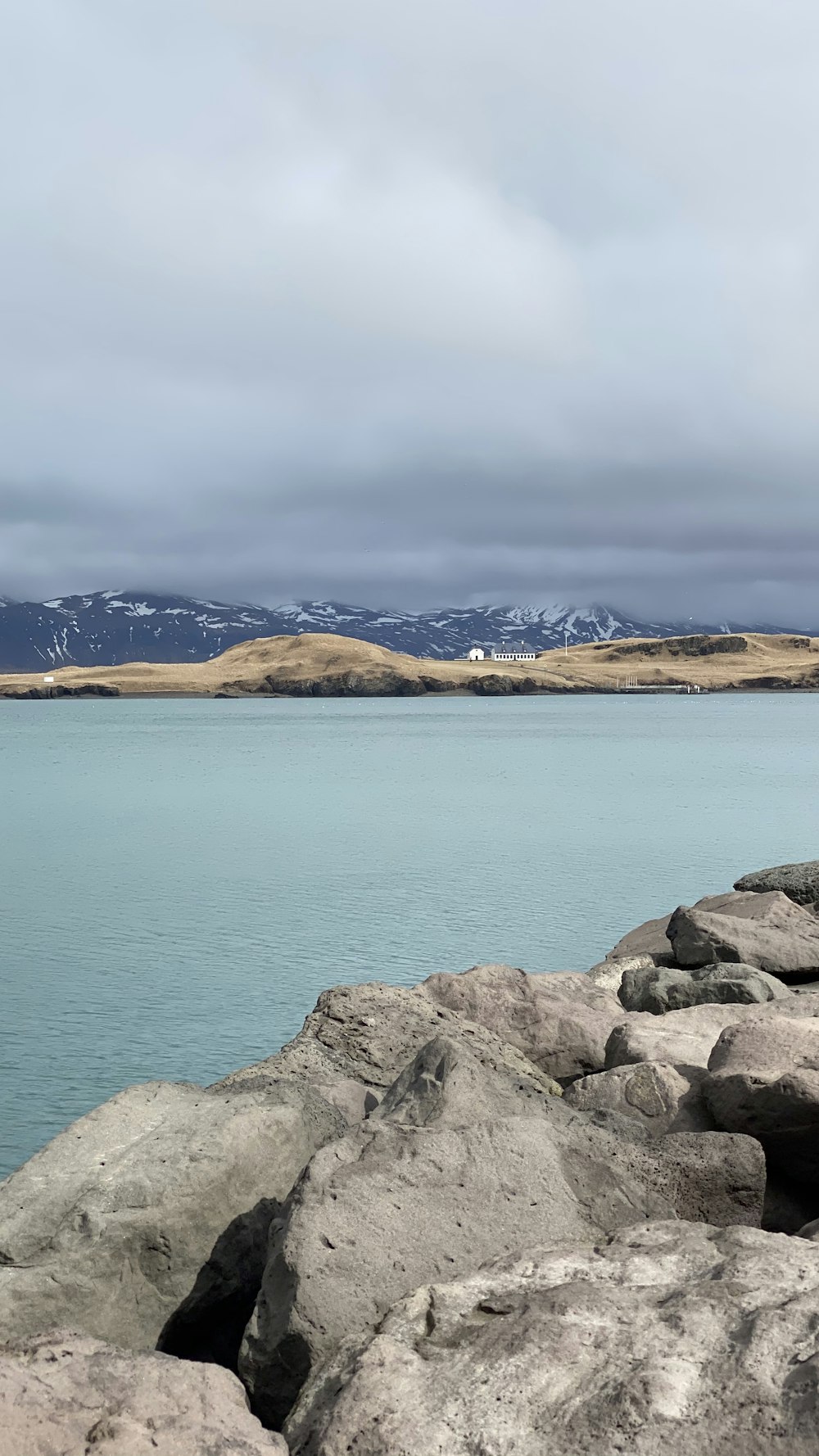 brown and gray rocky mountain beside blue sea under blue sky during daytime