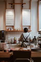 woman in gray shirt sitting on chair in front of table