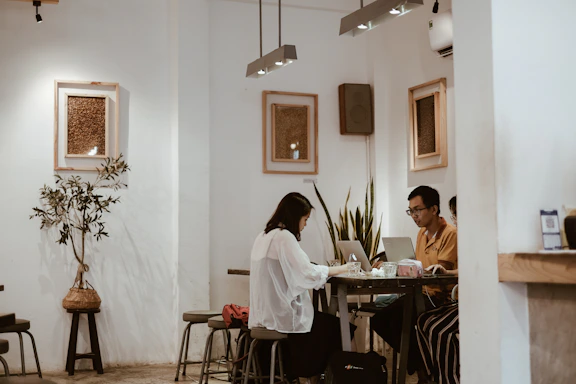 Cozy Scandinavian-style restaurant corner with digital marketing team planning on laptops.