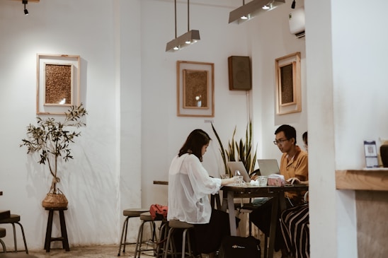 A warm, inviting workspace with two entrepreneurs sharing a laugh over coffee, surrounded by startup sketches and laptops.