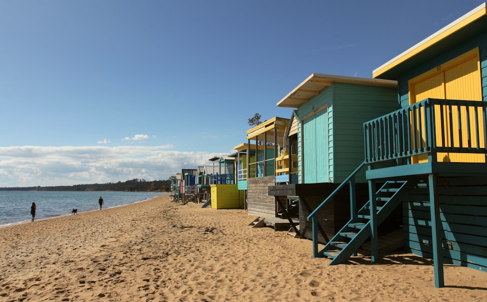 a row of beach huts next to a body of water