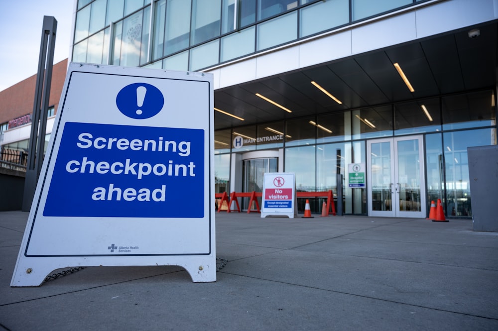 a blue and white sign sitting in front of a building