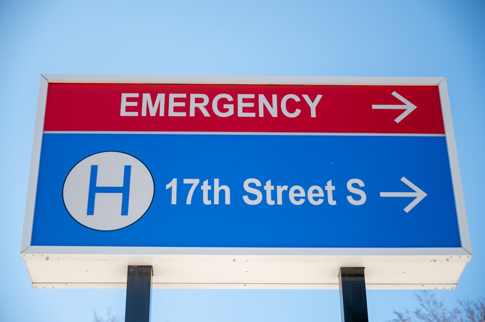 a blue and red emergency sign with an arrow pointing to the left