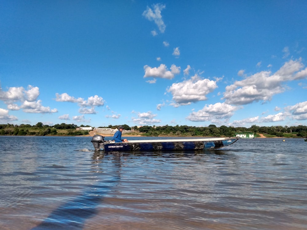 blue and white boat on sea under blue sky and white clouds during daytime