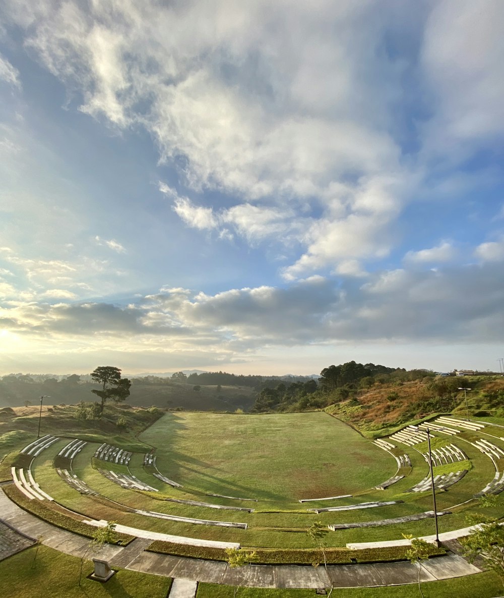 campo di erba verde sotto il cielo nuvoloso durante il giorno