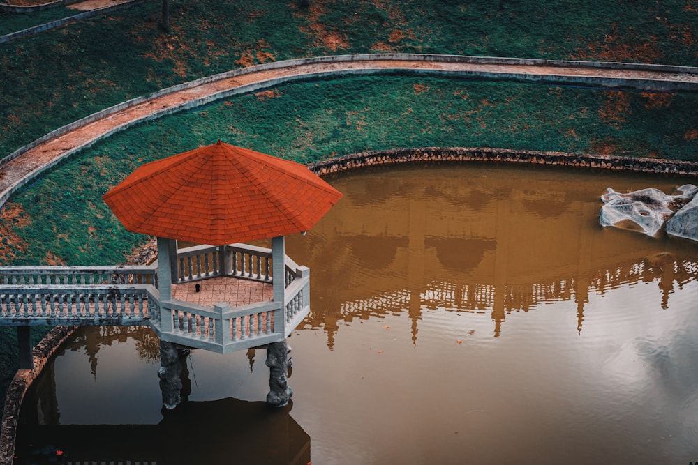 Bâtiment en béton brun et blanc près d’un plan d’eau pendant la journée