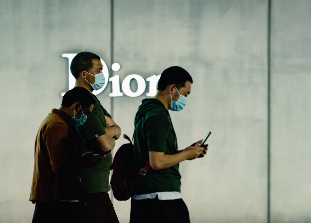 man in green shirt holding smartphone