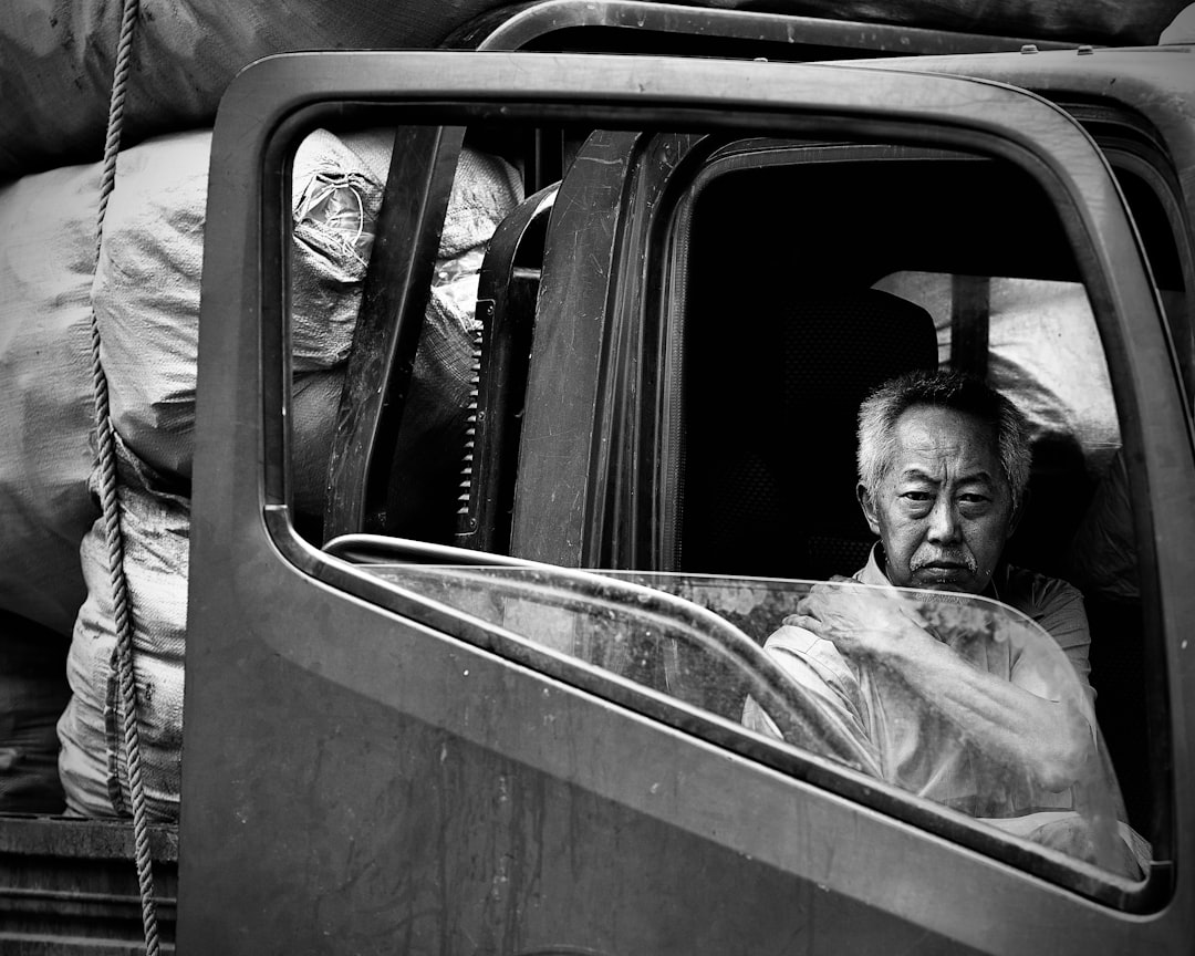 grayscale photo of man in car