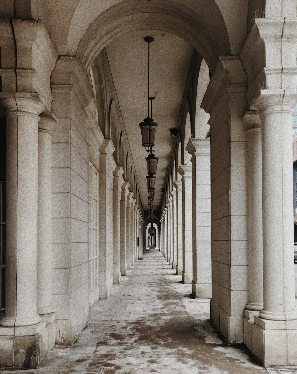 white concrete hallway with black metal lamp posts