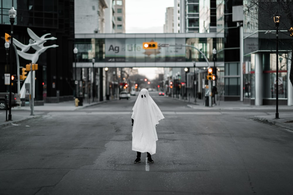 woman in white dress walking on pedestrian lane during daytime