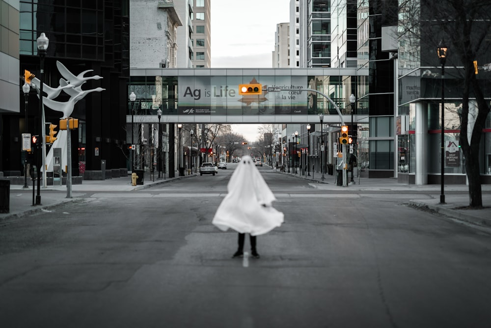 woman in white dress walking on pedestrian lane during daytime