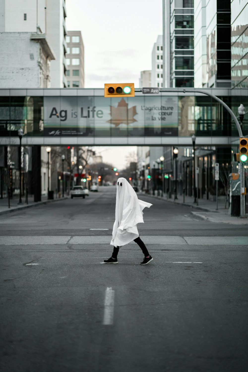 person in white robe walking on sidewalk during daytime