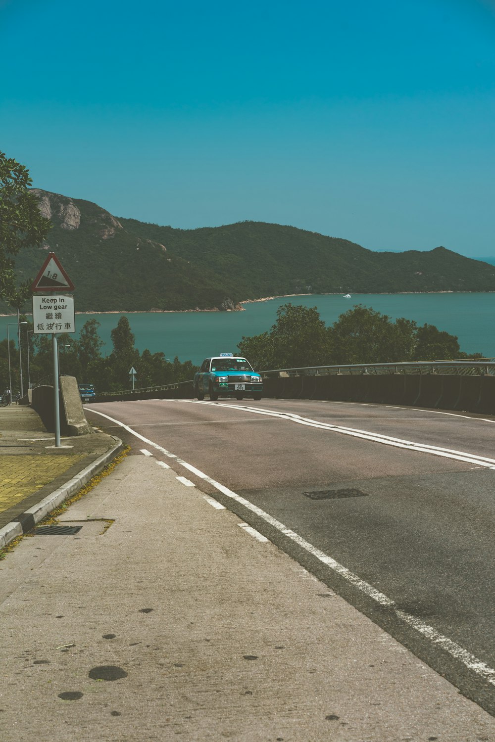 日中の水域近くの道路を走るグリーンカー