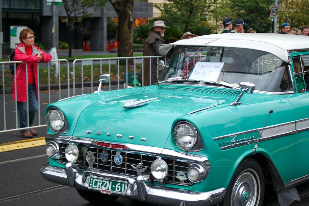 teal car parked near green trees during daytime