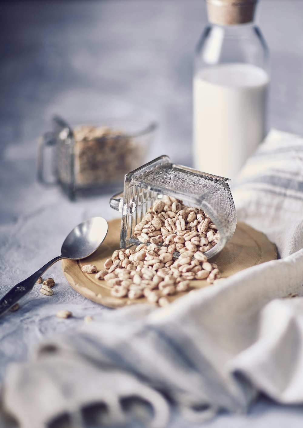 brown peanuts on stainless steel spoon beside white ceramic mug