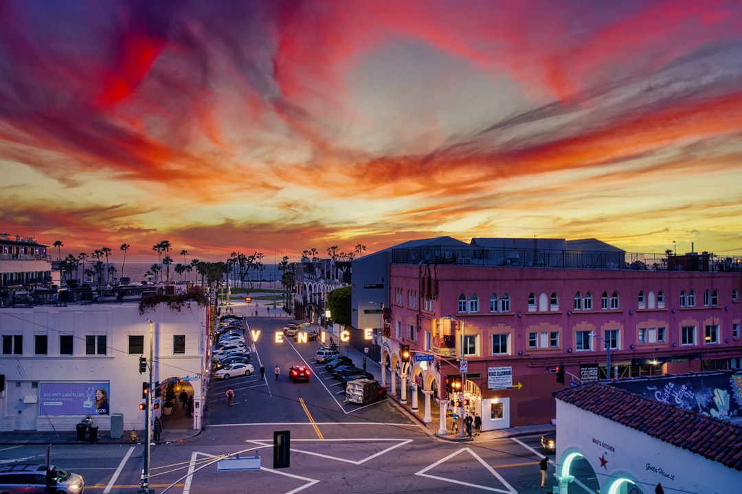 cars parked on street near buildings during sunset